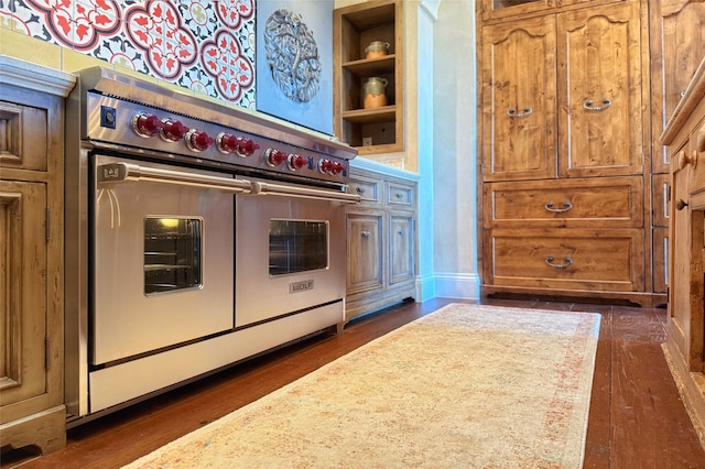 kitchen with built in features, brown cabinets, dark wood-style flooring, and range with two ovens