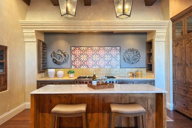 kitchen featuring backsplash, a center island, baseboards, dark wood finished floors, and a kitchen breakfast bar