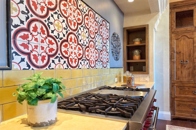 kitchen featuring built in shelves, baseboards, recessed lighting, decorative backsplash, and glass insert cabinets