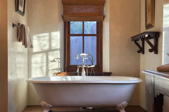 bathroom with a soaking tub and a sink