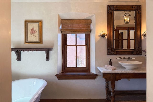 bathroom with a freestanding bath and a sink