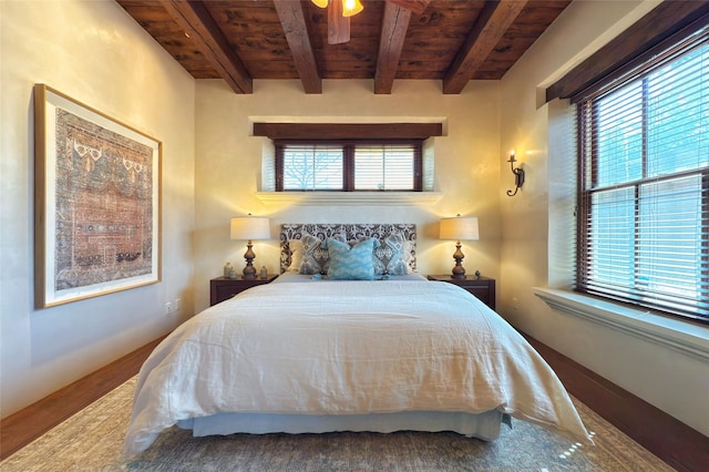 bedroom with beamed ceiling, wooden ceiling, and baseboards