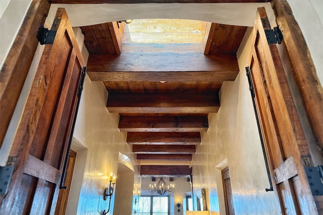 stairs featuring an inviting chandelier, beam ceiling, and a high ceiling