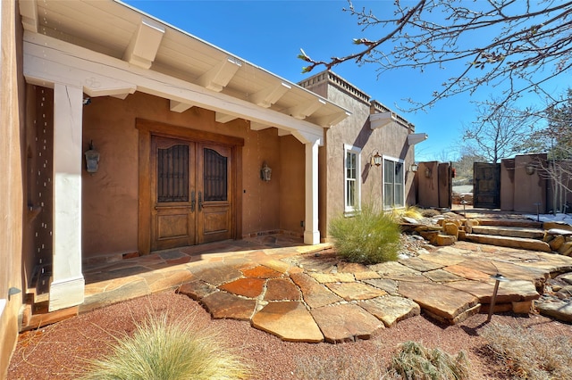 doorway to property featuring stucco siding