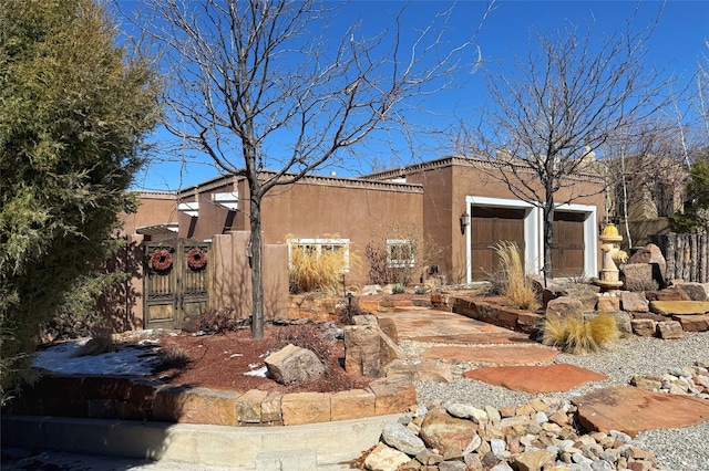 exterior space featuring a gate, stucco siding, and fence