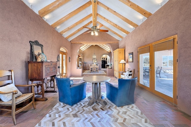 living area featuring beam ceiling, arched walkways, brick floor, and high vaulted ceiling