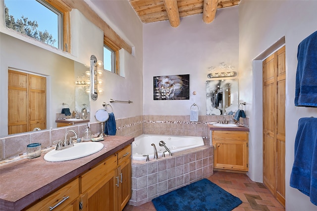 full bathroom featuring beam ceiling, a sink, wooden ceiling, brick floor, and a bath