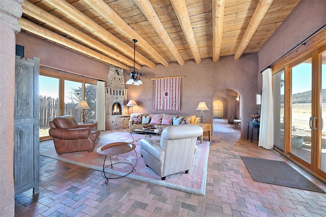 living room with arched walkways, brick floor, and a wealth of natural light