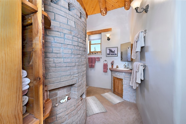 bathroom featuring brick wall and vanity