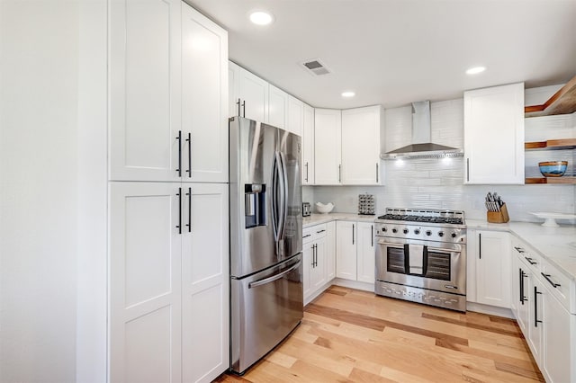 kitchen with visible vents, light wood-style flooring, open shelves, stainless steel appliances, and wall chimney range hood