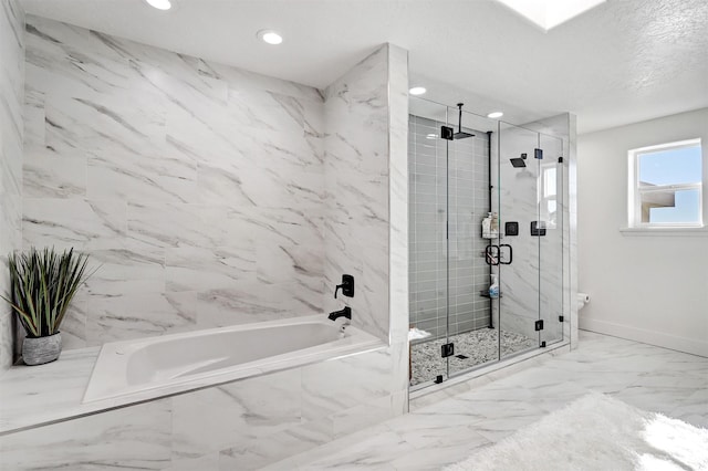 full bath with baseboards, a garden tub, marble finish floor, and a stall shower