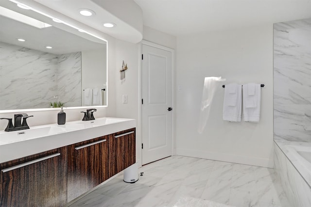 full bath featuring baseboards, double vanity, recessed lighting, a bathtub, and marble finish floor