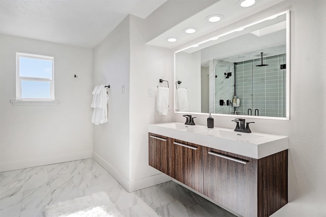 full bathroom featuring marble finish floor, a shower stall, baseboards, and a sink