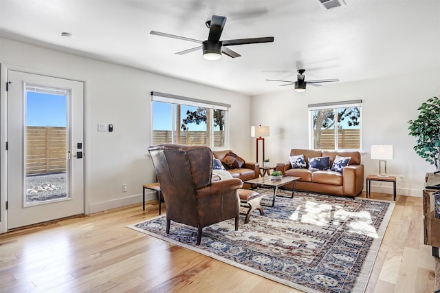 living area featuring baseboards, plenty of natural light, and light wood-style flooring