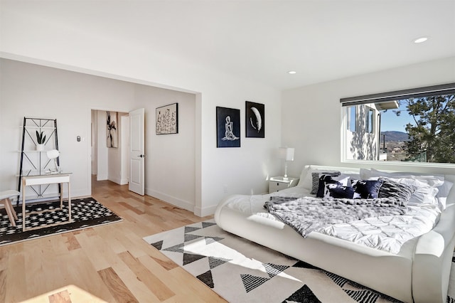 bedroom with recessed lighting, wood finished floors, and baseboards