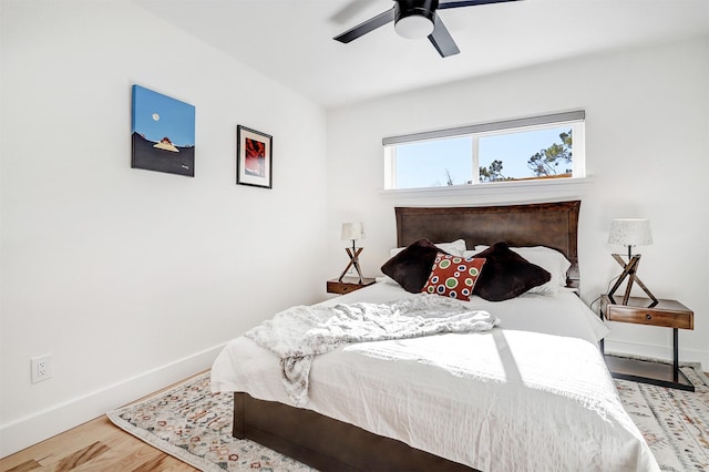 bedroom with a ceiling fan, baseboards, and wood finished floors