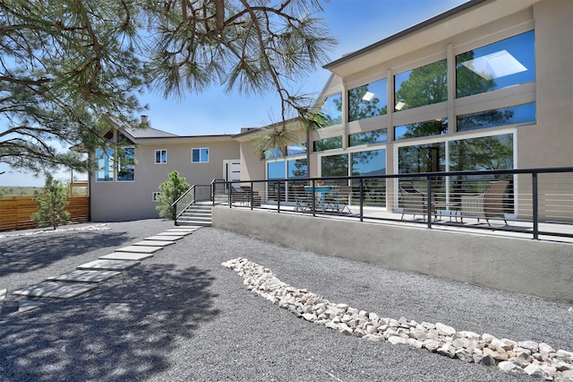 exterior space featuring stucco siding and metal roof