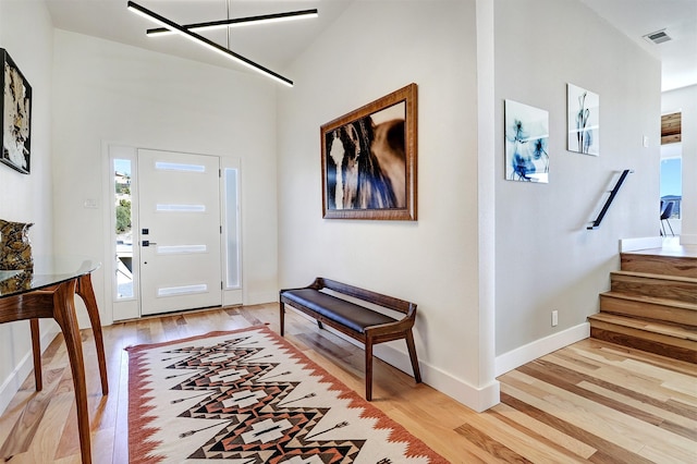 foyer with plenty of natural light, stairway, and light wood-style floors