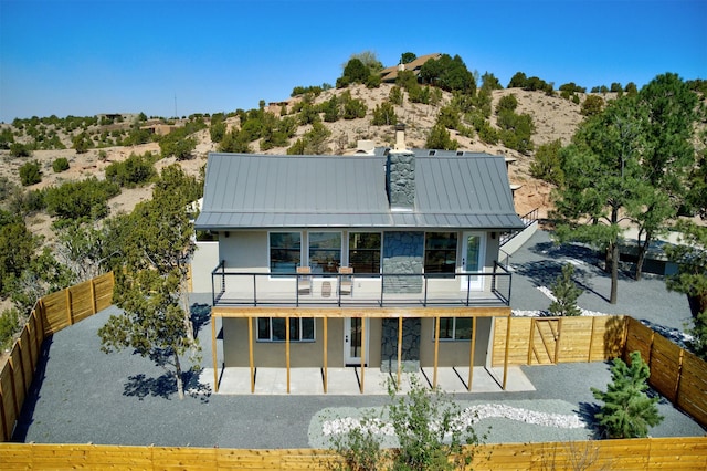 back of house with stucco siding, a standing seam roof, and a patio area