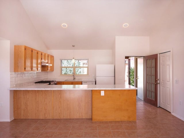 kitchen with under cabinet range hood, freestanding refrigerator, a peninsula, light countertops, and range