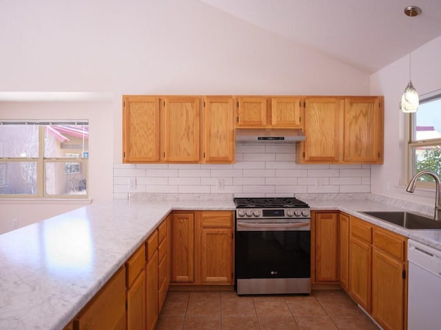 kitchen featuring under cabinet range hood, gas range, lofted ceiling, white dishwasher, and a sink