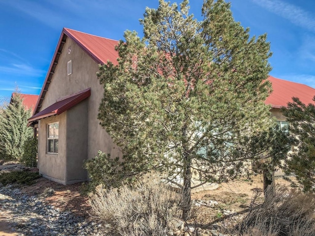 view of home's exterior featuring stucco siding and metal roof