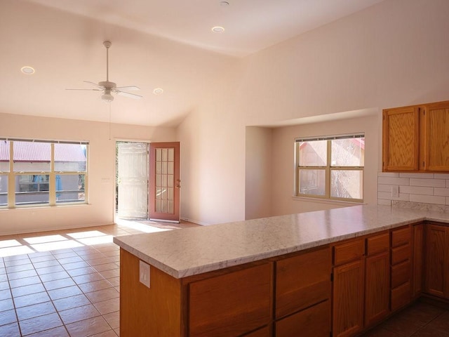 kitchen with open floor plan, a peninsula, decorative backsplash, lofted ceiling, and ceiling fan