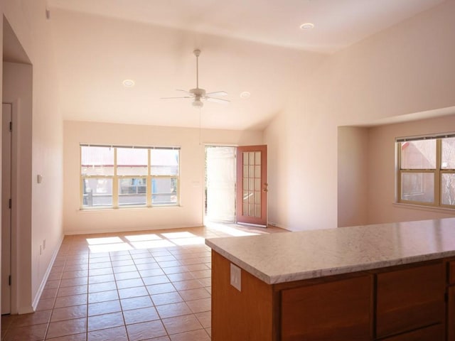 kitchen featuring light tile patterned floors, plenty of natural light, open floor plan, and vaulted ceiling