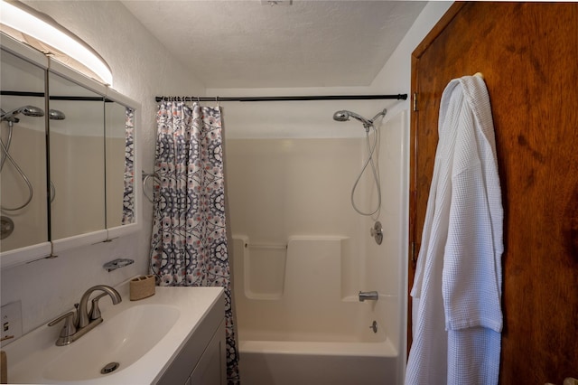 bathroom with vanity, shower / bath combination with curtain, and a textured ceiling