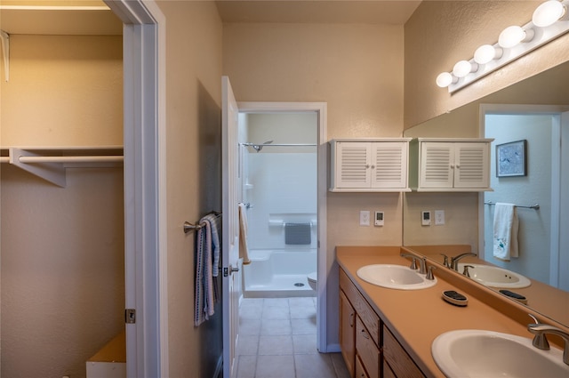 bathroom with tile patterned floors, a shower, and a sink