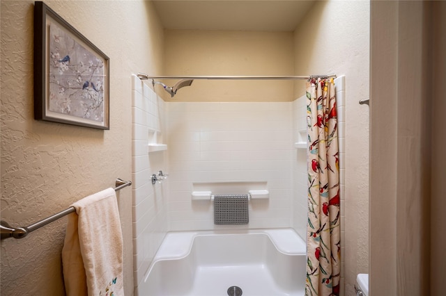 full bathroom featuring a shower with curtain and a textured wall