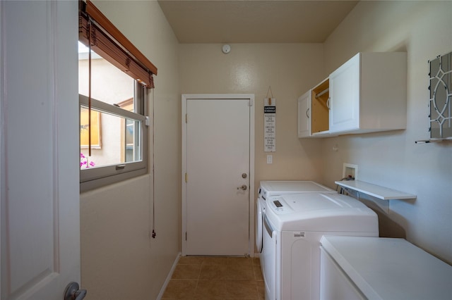 washroom featuring light tile patterned flooring, washing machine and dryer, cabinet space, and baseboards