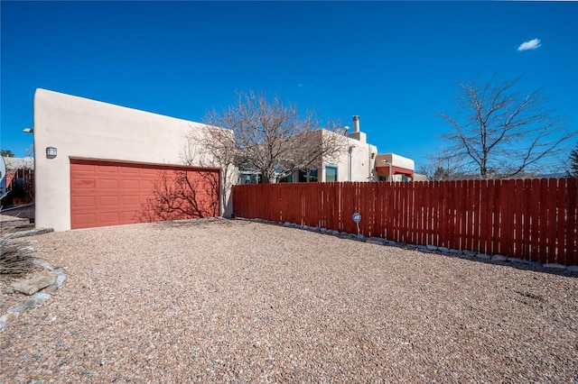 view of yard with gravel driveway, fence, and a garage