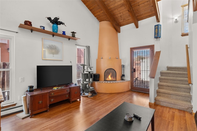 living room with wood ceiling, stairs, beam ceiling, baseboard heating, and light wood-style flooring