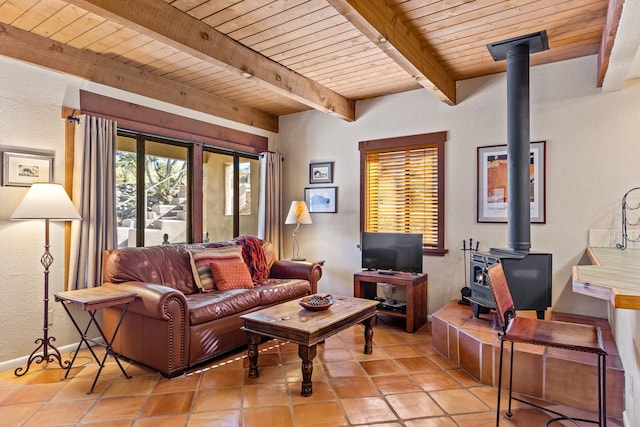 living room featuring light tile patterned floors, beamed ceiling, wooden ceiling, and a wood stove