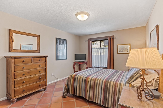 bedroom featuring tile patterned flooring, baseboards, and a textured ceiling