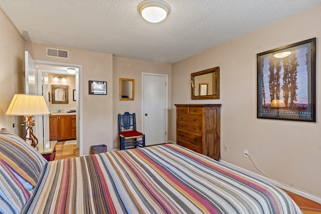 bedroom with visible vents and a textured ceiling