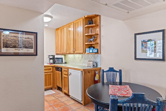 kitchen with visible vents, tile countertops, decorative backsplash, fridge, and open shelves