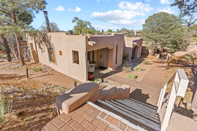 rear view of property featuring stucco siding