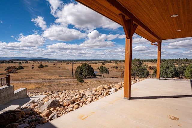 view of patio with a rural view and a mountain view