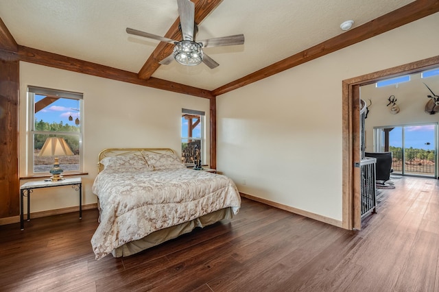 bedroom with baseboards, beam ceiling, and wood finished floors