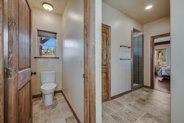 ensuite bathroom with toilet, baseboards, and ensuite bathroom