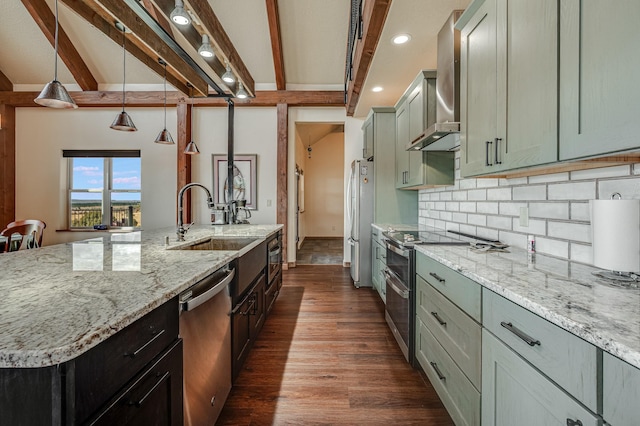 kitchen with beam ceiling, a sink, stainless steel appliances, wall chimney exhaust hood, and backsplash