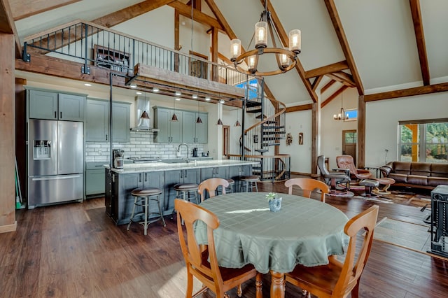 dining area featuring beamed ceiling, high vaulted ceiling, stairway, a chandelier, and dark wood-style flooring