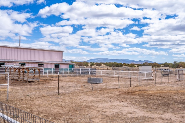 view of yard featuring an exterior structure, a mountain view, and an outdoor structure