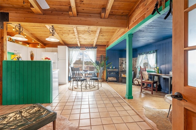 dining room with beam ceiling, plenty of natural light, wood ceiling, and a wood stove