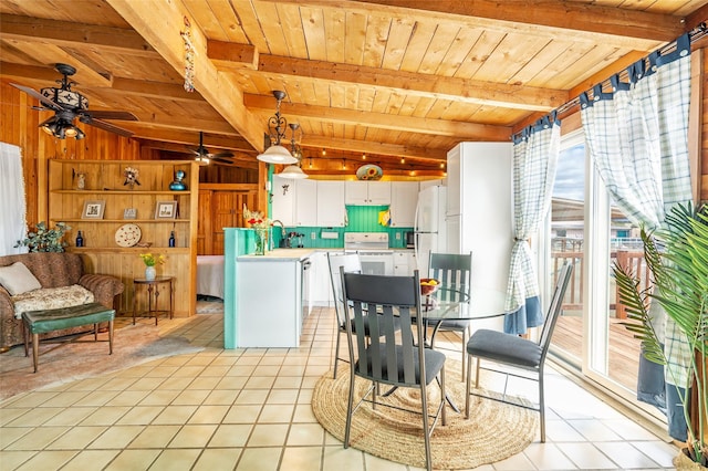 dining space featuring a ceiling fan, wooden ceiling, wood walls, light tile patterned floors, and vaulted ceiling with beams