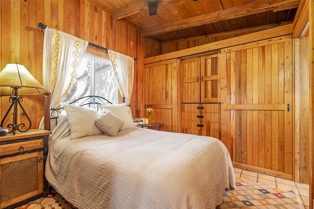 bedroom with beam ceiling, wood walls, and wooden ceiling