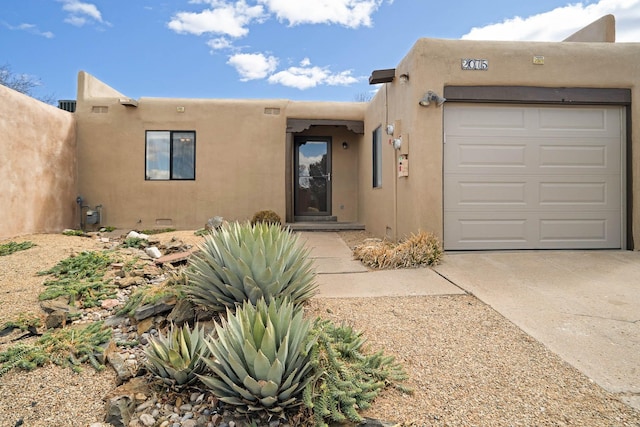 southwest-style home featuring stucco siding, an attached garage, and driveway