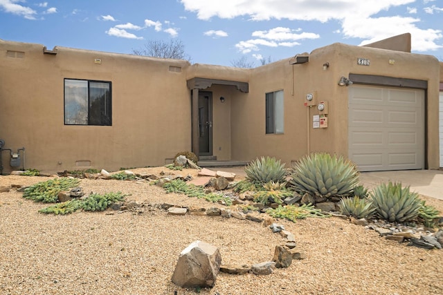 southwest-style home with a garage, concrete driveway, and stucco siding